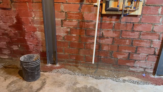 Foundation excavation work at a residential home showing trenching along the foundation wall for pier installation