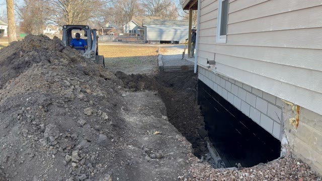 Structural foundation repair work at basement level showing wall stabilization and pier installation by JLB