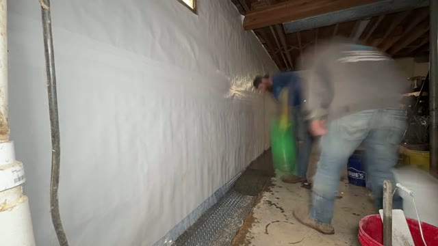 Pouring concrete back over an interior drainage channel after drain tile installation in a basement waterproofing project